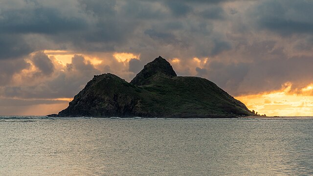 View of Moku Nui, the larger of the two islands known as "The Mokes," located just off the pristine white sands of Lanakai Beach in Kailua, Oahu. Moku Nui is pictured, showcasing its lush greenery and bird sanctuary.